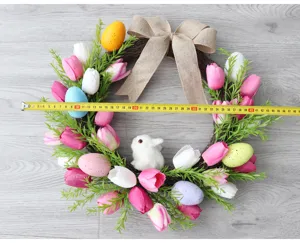 Osterkranz Haustür Dekoration mit künstlichen Tulpen bunten Eiern und Jute Schleife Frühling.