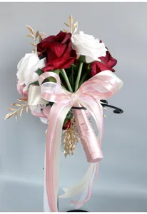 Europäischer Brautstrauß mit roten weißen Rosen goldenen Blättern und rosa Schleife für Hochzeiten.