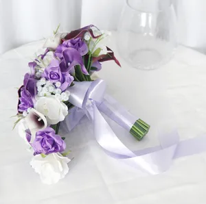 Detalle de ramo de novia artificial con rosas moradas y calas blancas con cinta de raso.