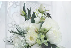 Nahaufnahme des weißen künstlichen Rosenstrauchs mit grünen Blättern für Hochzeitsfotografie.