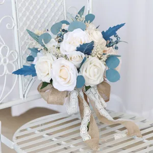 Splendido bouquet da sposa artificiale di rose bianche con foglie di eucalipto blu e nastro di pizzo.
