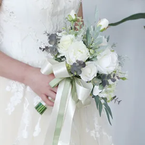 Eleganter künstlicher Hochzeitsblumenstrauß mit weißen Rosen und grünen Eukalyptusblättern.
