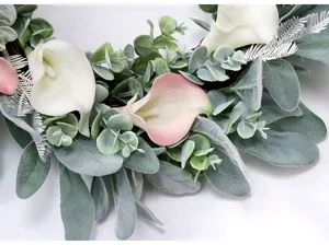 Dettaglio in primo piano di ghirlanda di calla artificiali con foglie di eucalipto.