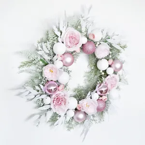 Pink Christmas wreath with pink and white balls and floral decorations for home holiday decor.