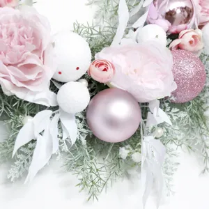 Pink Christmas wreath with baubles and flowers for holiday home wall wedding decoration.