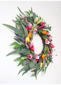 Detailansicht des künstlichen Frühlingskranzes mit bunten Tulpen und Eukalyptus für die Haustür.