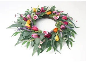 Künstlicher Frühlingsblumenkranz mit bunten Tulpen Orchideen und Eukalyptusblättern.