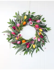 Künstlicher Frühlingsblumenkranz mit bunten Tulpen und Orangen für Haustür und Heim.