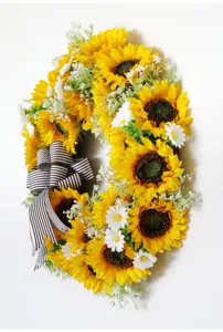 Kunstmatige zonnebloemkrans met bruin-wit gestreept lint voor herfst huisdecoratie.