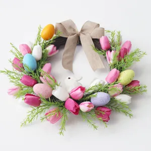Osterkranz mit bunten Eiern, rosa weißen Tulpen und Jute Schleife für Haustür Frühlingsdeko.