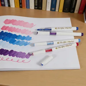 Close-up detail of acrylic marker pens showing vivid color swatches on paper on a wooden desk.