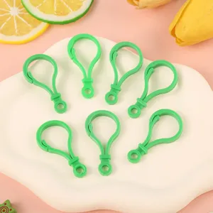 Green plastic lobster clasps for DIY jewelry keychains and toy pendants detail view.