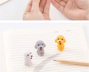 Close-up detail of cute cartoon puppy shaped erasers on lined notebook paper with pencil.