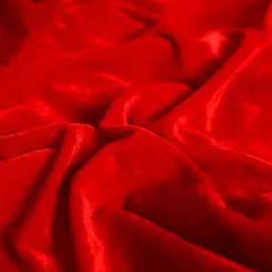 Primo piano dettagliato di un tessuto di velluto rosso lussuoso con morbida consistenza.