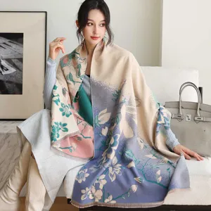 Detail shot of a thick Chinese style floral cashmere shawl, worn by model in a cozy interior setting.