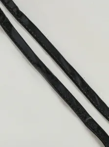 Black glossy patent leather binding straps detail close up, showing fine edge stitching.