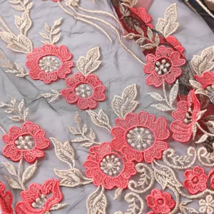 Detaillierte Nahaufnahme von schwarzem Netztoff mit roter Blumen- und Beigestickerei.