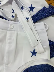 Close-up detail of white cheerleader costume with blue glitter stars and straps for cosplay.