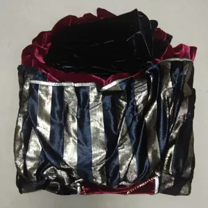 Detailed view of black and gold striped velvet fabric and red trim for pirate costume.