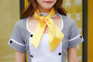 Cosplay anime chef maid costume detail featuring houndstooth sleeves and bright yellow scarf.