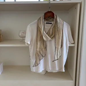 Detailed view of a retro linen narrow scarf draped on a white tee, perfect for minimalist styling.