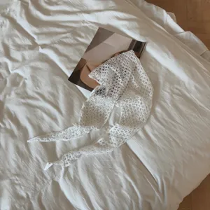 White floral lace hollow-out triangle scarf detail, delicate woven texture for versatile outfit.