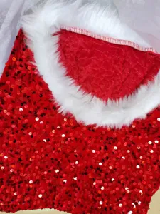 Close-up of red sequin Christmas costume fabric with white fluffy faux fur trim detail.
