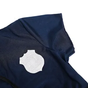 Close-up detail shot of the dark blue costume sleeve featuring a white embroidered badge.