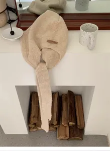 Vista dettagliata del passamontagna sciarpa in maglia beige con lunghi nastri.