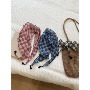 Close-up of vintage floral checkered triangular scarves with cute tassels, aesthetic design.
