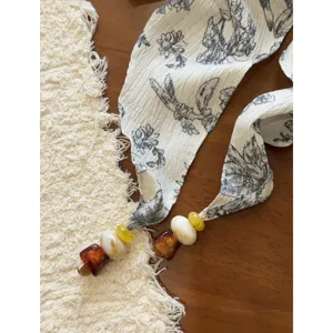 Close-up detail of vintage floral cotton linen ribbon strap with decorative beads, exquisite accessory.