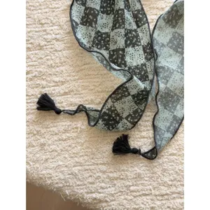 Detail view of a vintage Japanese style floral checkered kerchief with cute black tassels.