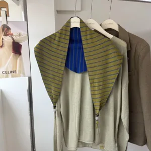 Two-sided contrast striped knitted triangle scarf shawl paired with a stylish light green top.