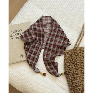 Retro plaid triangle scarf detail showing textured fabric and delicate bead ends for styling.