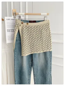 Detail view of Korean style hollow knit tie skirt overlay denim jeans, chic fake two-piece.