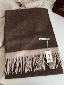 Detail view of premium 100% wool color-blocked winter scarf with elegant fringe trim.