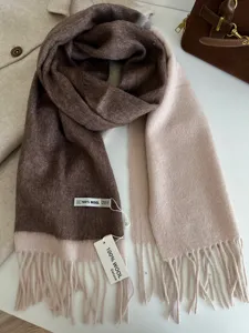 Close-up detail of the two-tone wool scarf showcasing soft brown and beige colors with fringes.