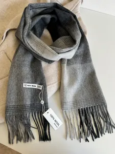 Close-up detail of grey gradient wool scarf with soft fringe, cozy winter accessory texture.