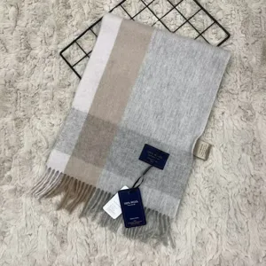 Detailed view of soft grey and beige plaid wool scarf with fringe, showing premium fabric texture.