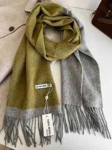 Detailed view of the double-sided color-block wool scarf with fine tassel fringe and soft texture.