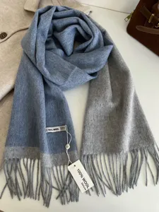 Luxurious wool colorblock scarf detail featuring elegant fringe trim and soft texture.