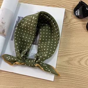 Details of vintage green cotton polka dot headscarf styled with magazine and sunglasses.