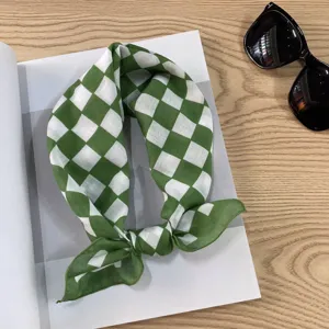 Detailed close-up view of green and white checkered cotton scarf showing soft fabric texture.