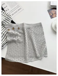 Close-up of grey hollow knit layering skirt with side buttons and mesh texture for spring styling.