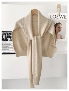 Detailed view of a cozy beige cable-knit winter shawl scarf, elegant knitted wrap for women.