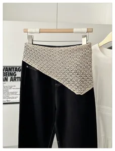 Close-up detail of the Korean style hollow knit triangular waist cover layered on denim pants.