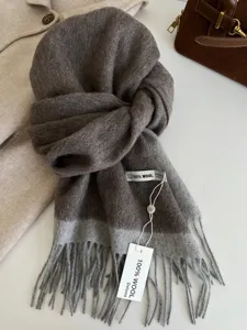 Close-up detail of luxury two-tone wool scarf with soft fringe and premium wool label.