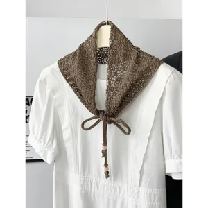 Chic hollow knit triangle scarf with beads and bow tie, elegant womens fashion shawl accessory.