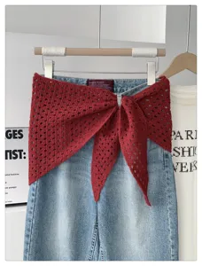 Stylish denim pants with red knitted hollow shawl detail, chic and trendy fashion wear.
