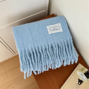 Detailed view of soft blue winter scarf with delicate lace patch, warm and cozy knit.